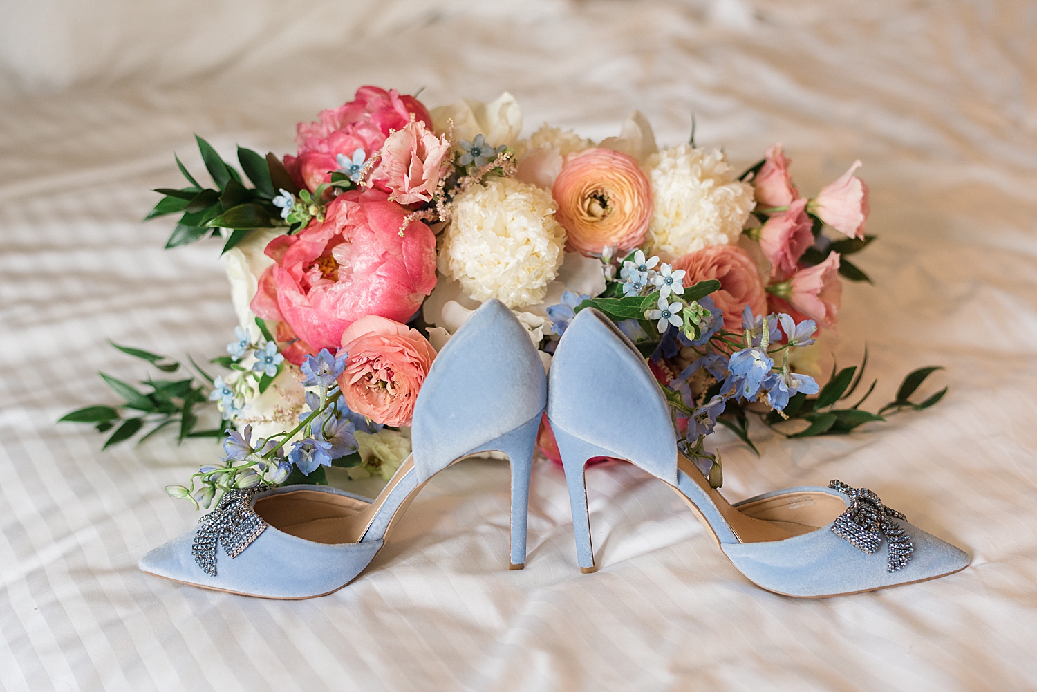 blue bridal shoes in front of pink summer bouquet