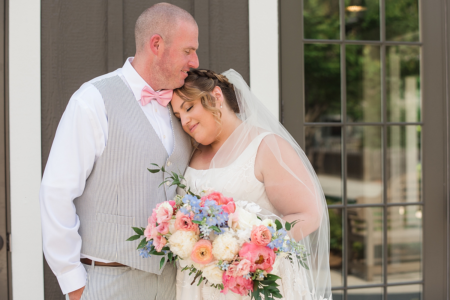 couple portrait summer wedding, bride rests head on groom's shoulder