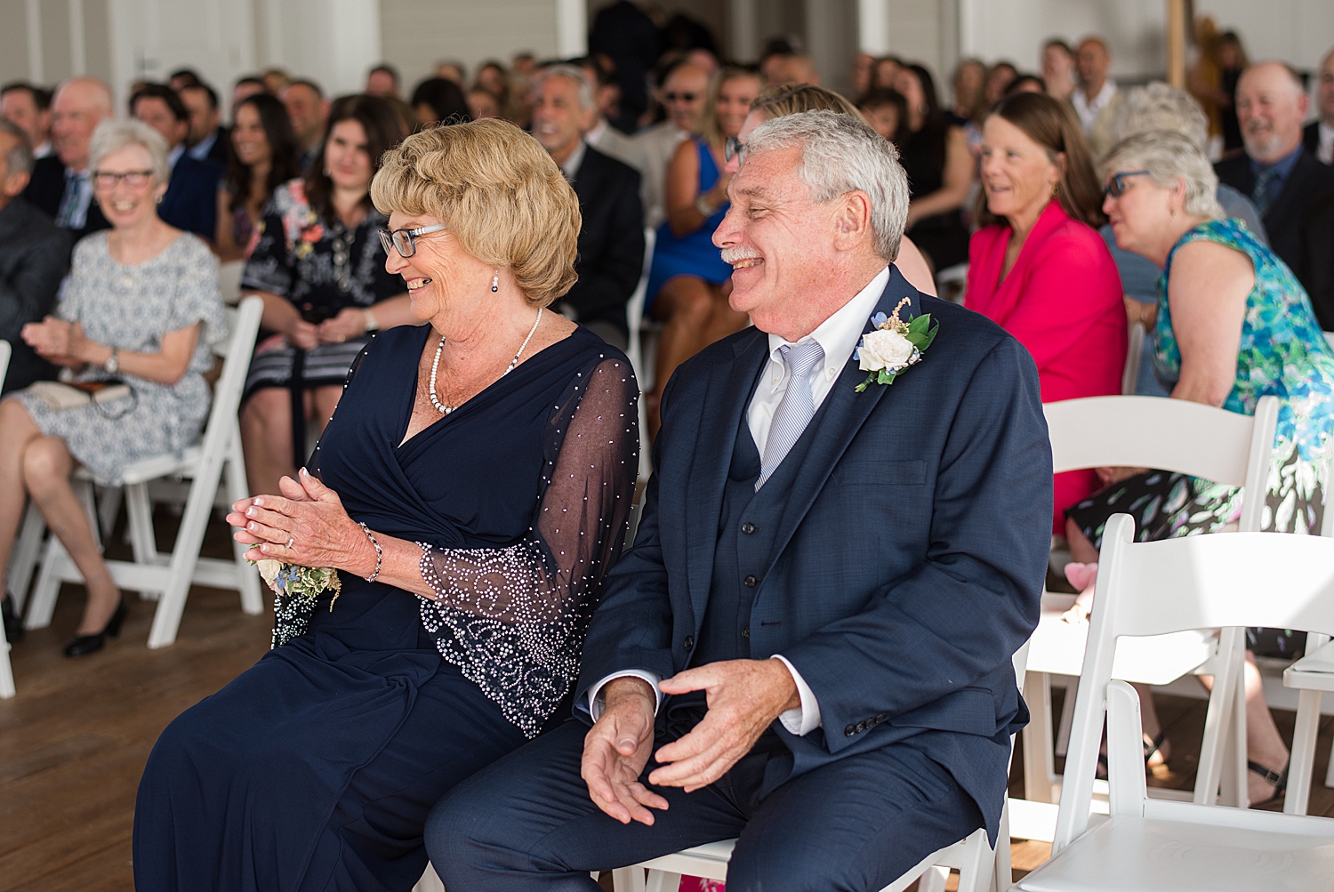 groom's parents smile in audience at ceremony