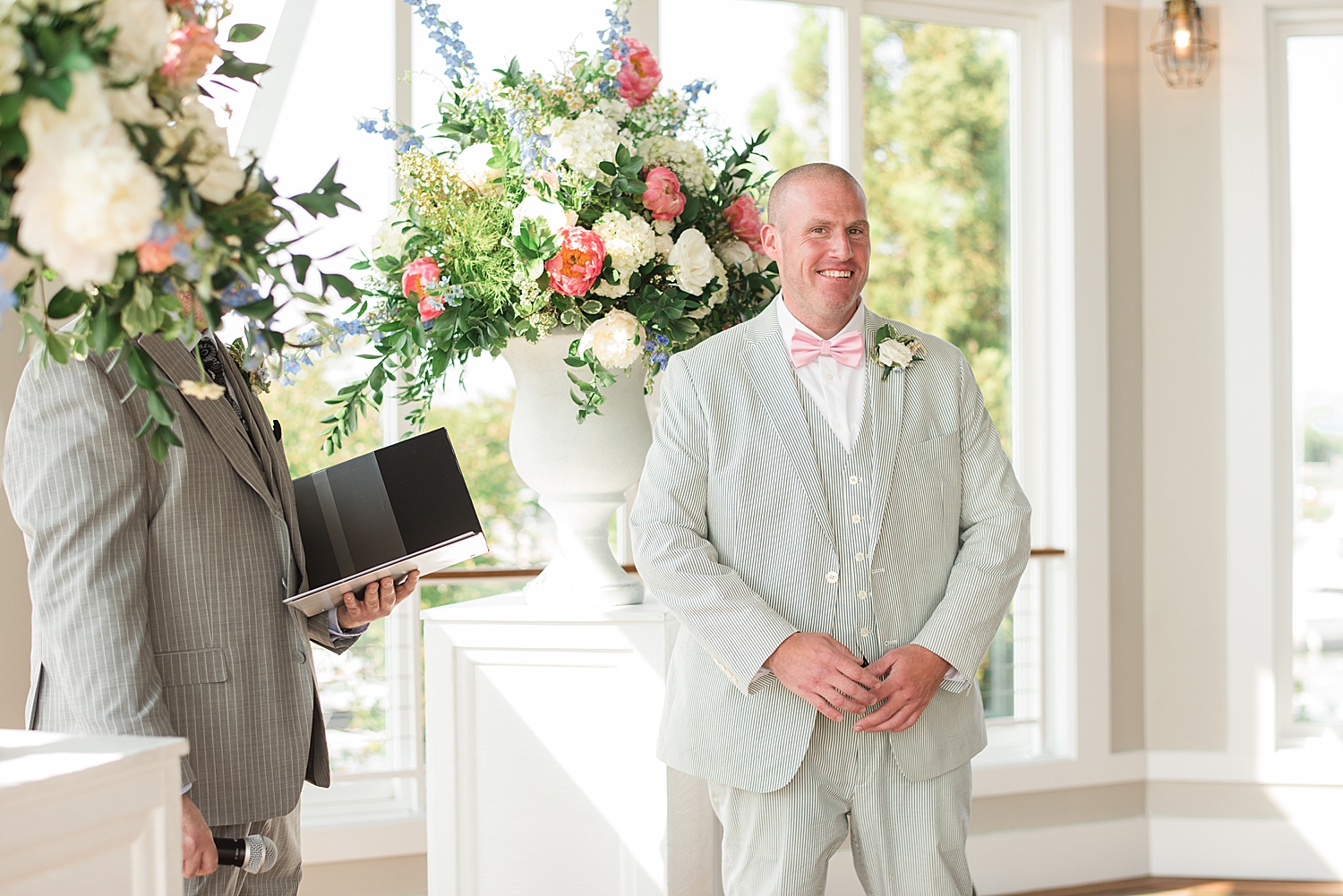 groom waits at end of aisle during ceremony