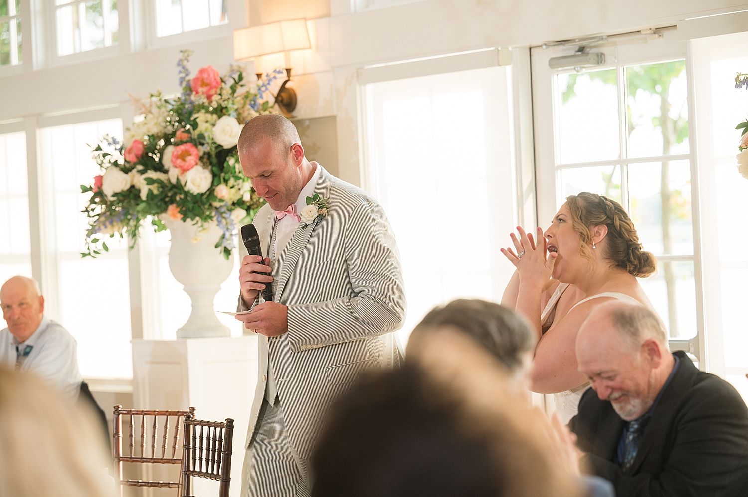 groom gives speech, bride cheers him on