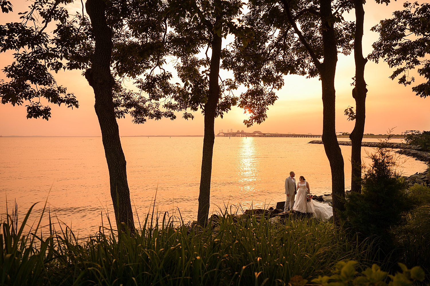 wide bride and groom sunset portrait on beach 