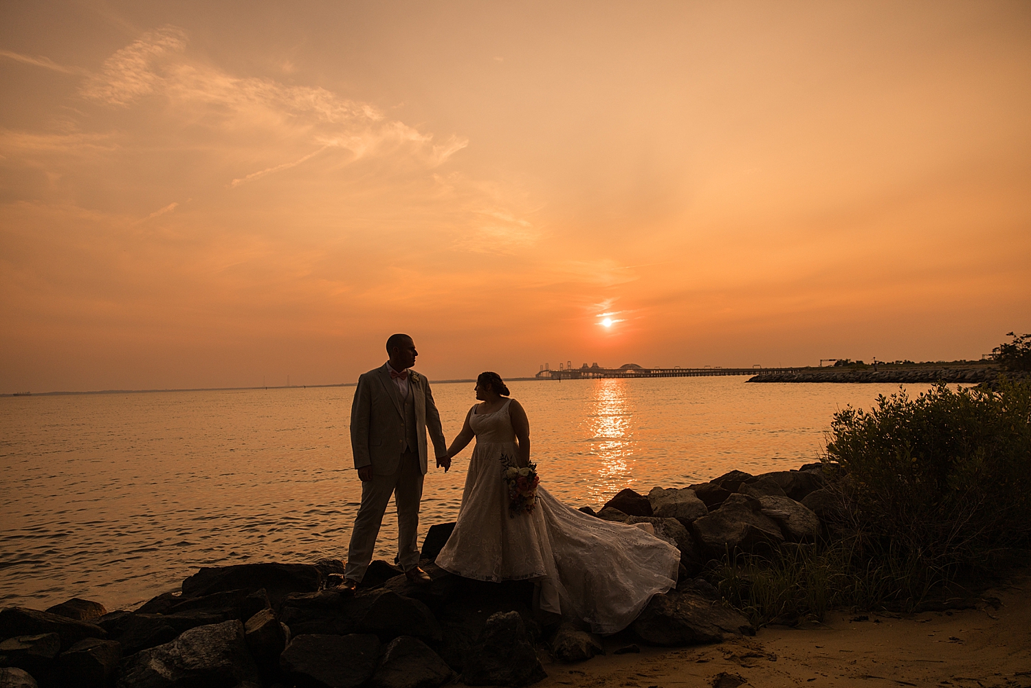 wide bride and groom sunset portrait on beach 