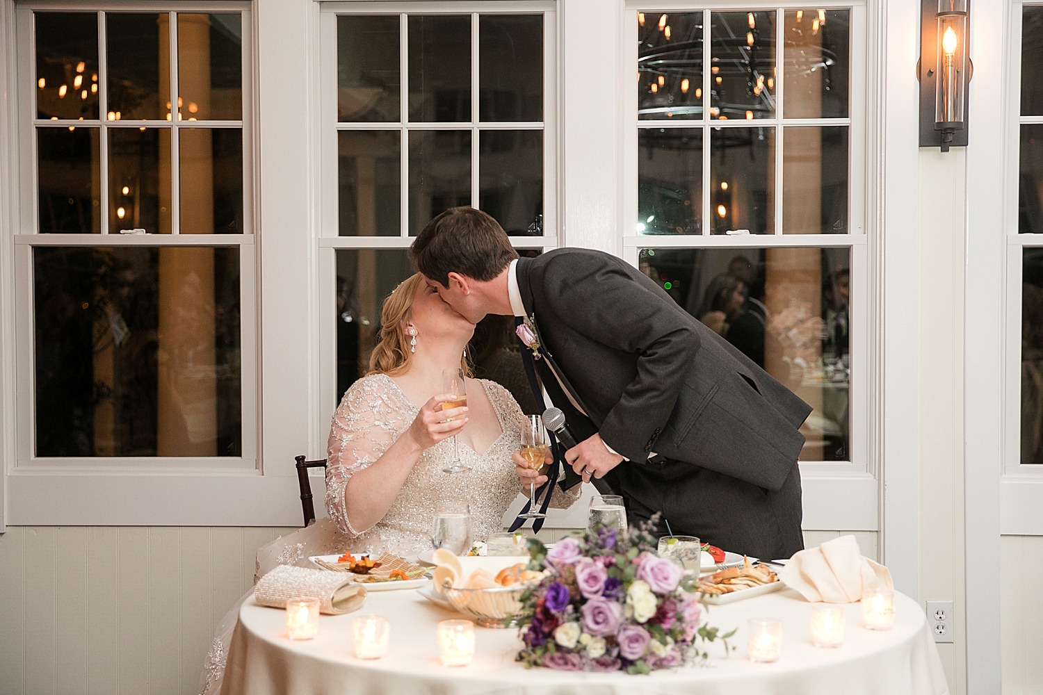 bride and groom kiss at sweetheart table