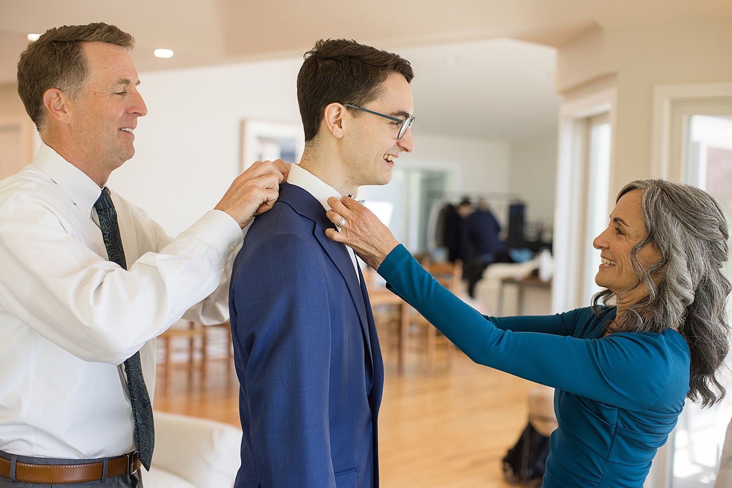 groom's parents help him get ready