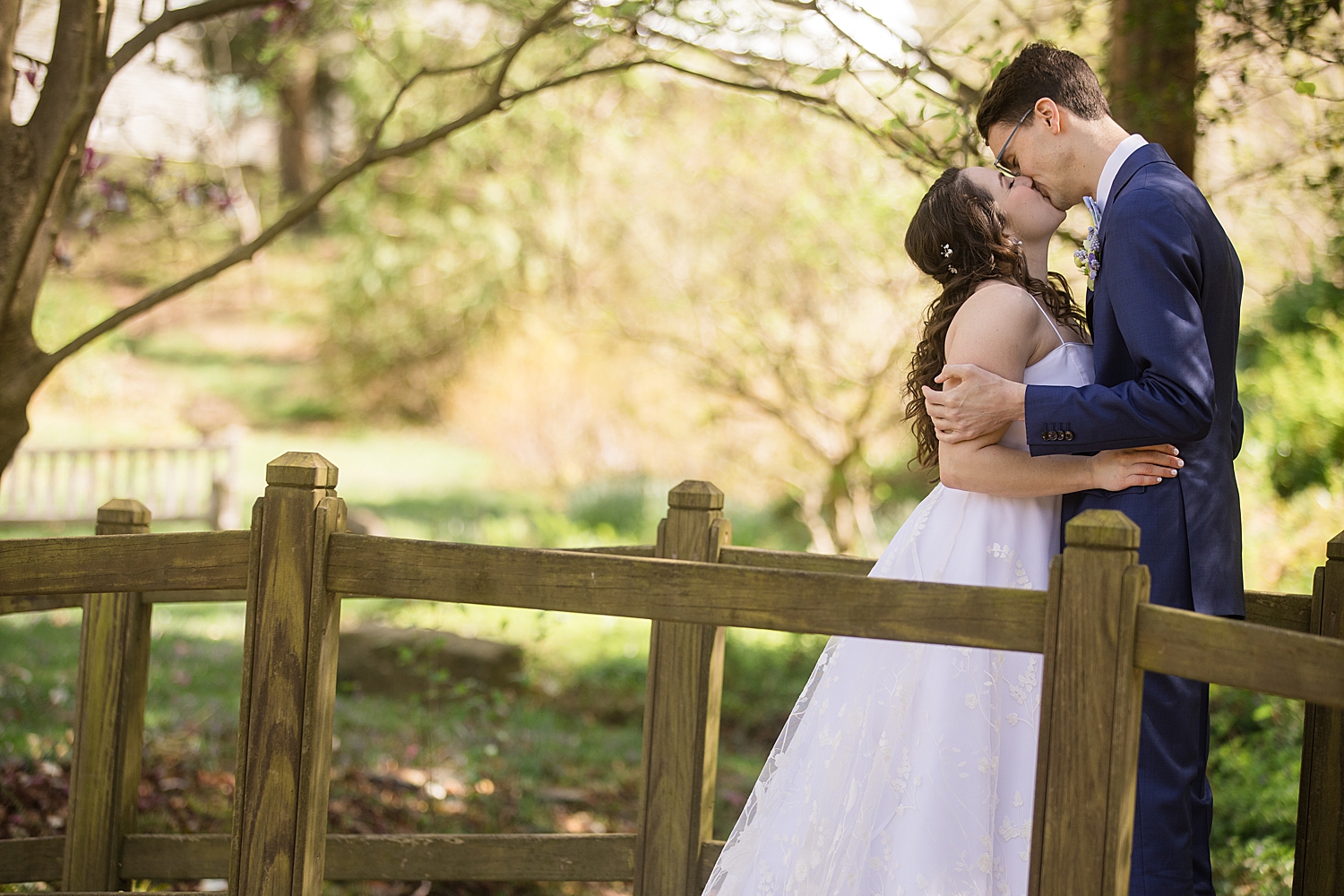 bride and groom kiss on bridge