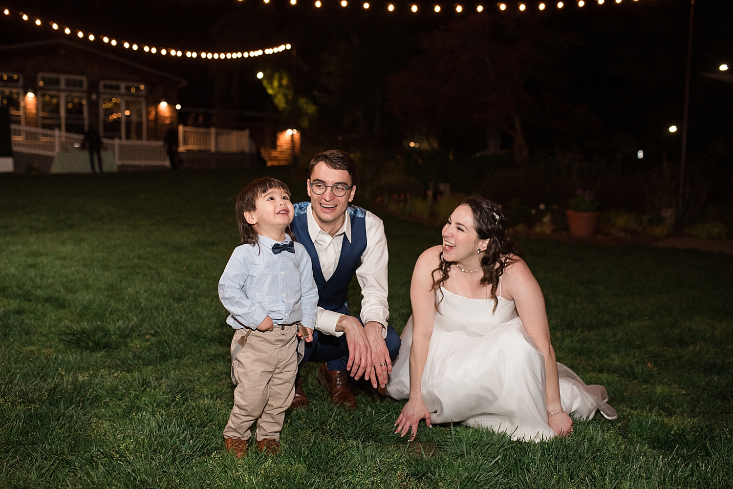 bride and groom in grass with ring bearer