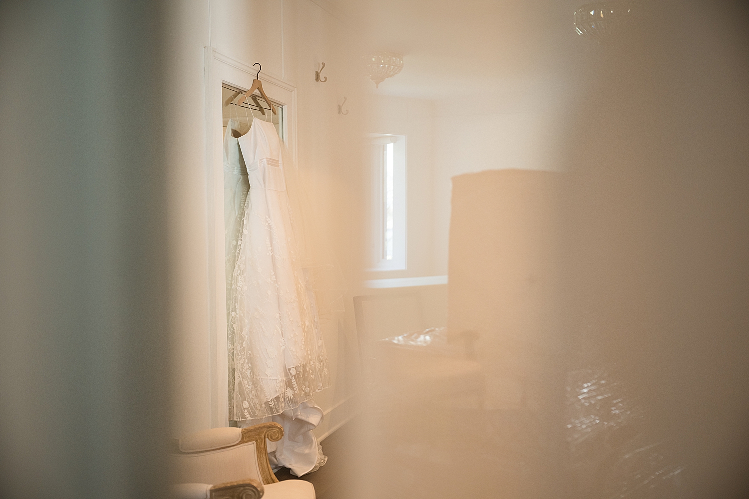 bridal gown hanging from door