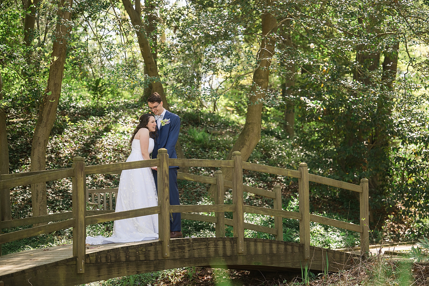 bride and groom on bridge among the trees