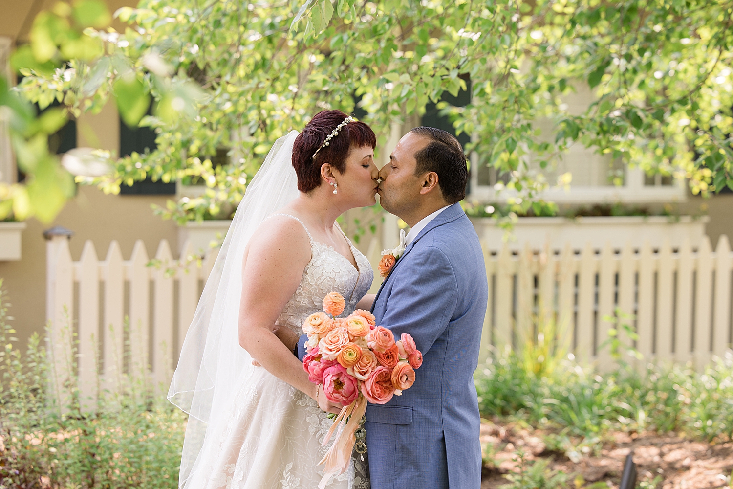 bride and groom portrait kiss, coral bouquet blue suit