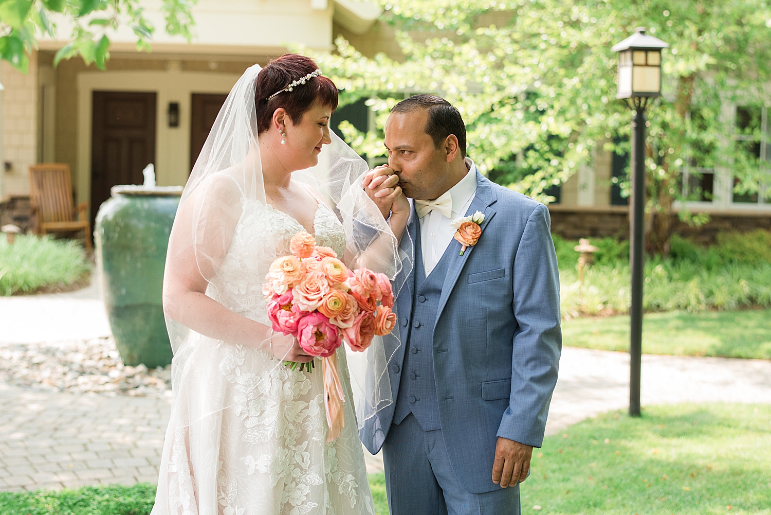 couple portrait groom kisses bride's hand