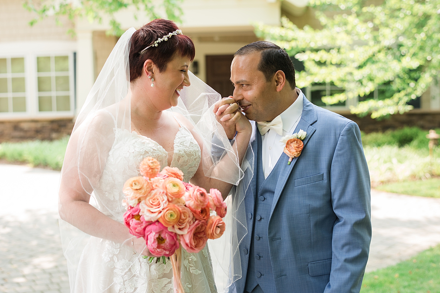 couple portrait groom kisses bride's hand