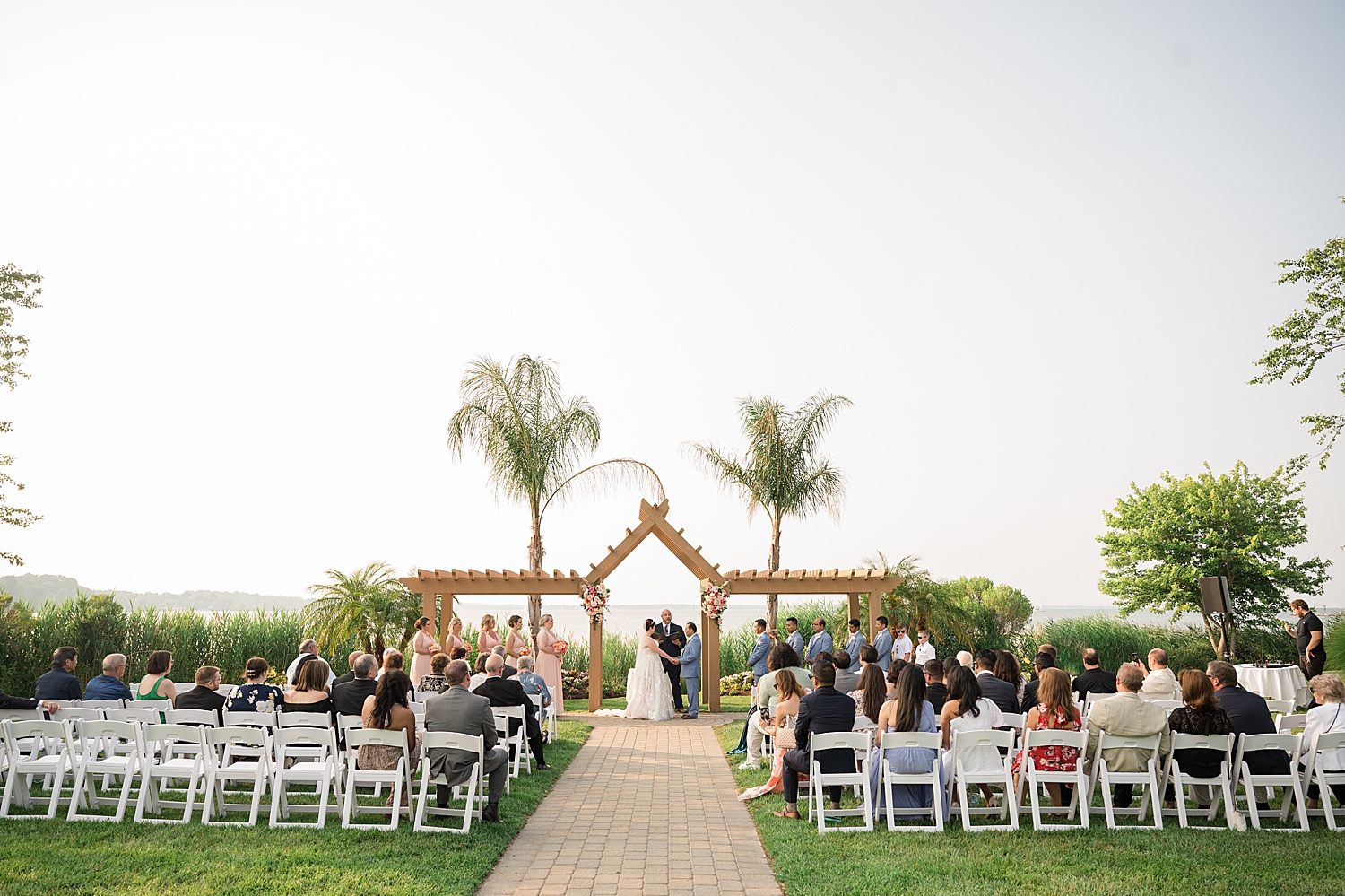 wide shot wedding ceremony waterfront beach