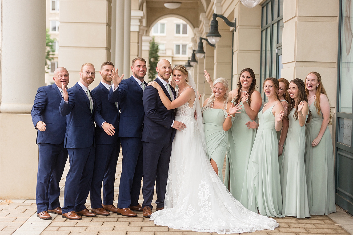 full wedding party photo, guys in navy, girls in sage