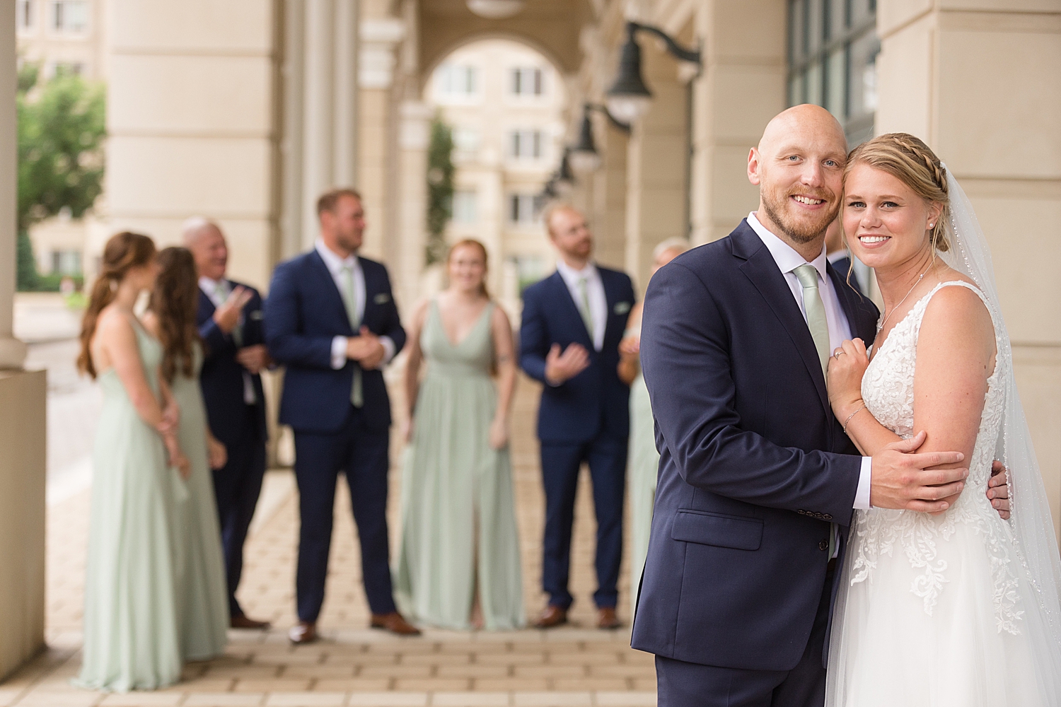 full wedding party photo, guys in navy, girls in sage