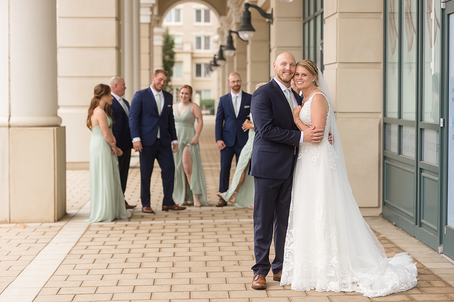 full wedding party photo, guys in navy, girls in sage