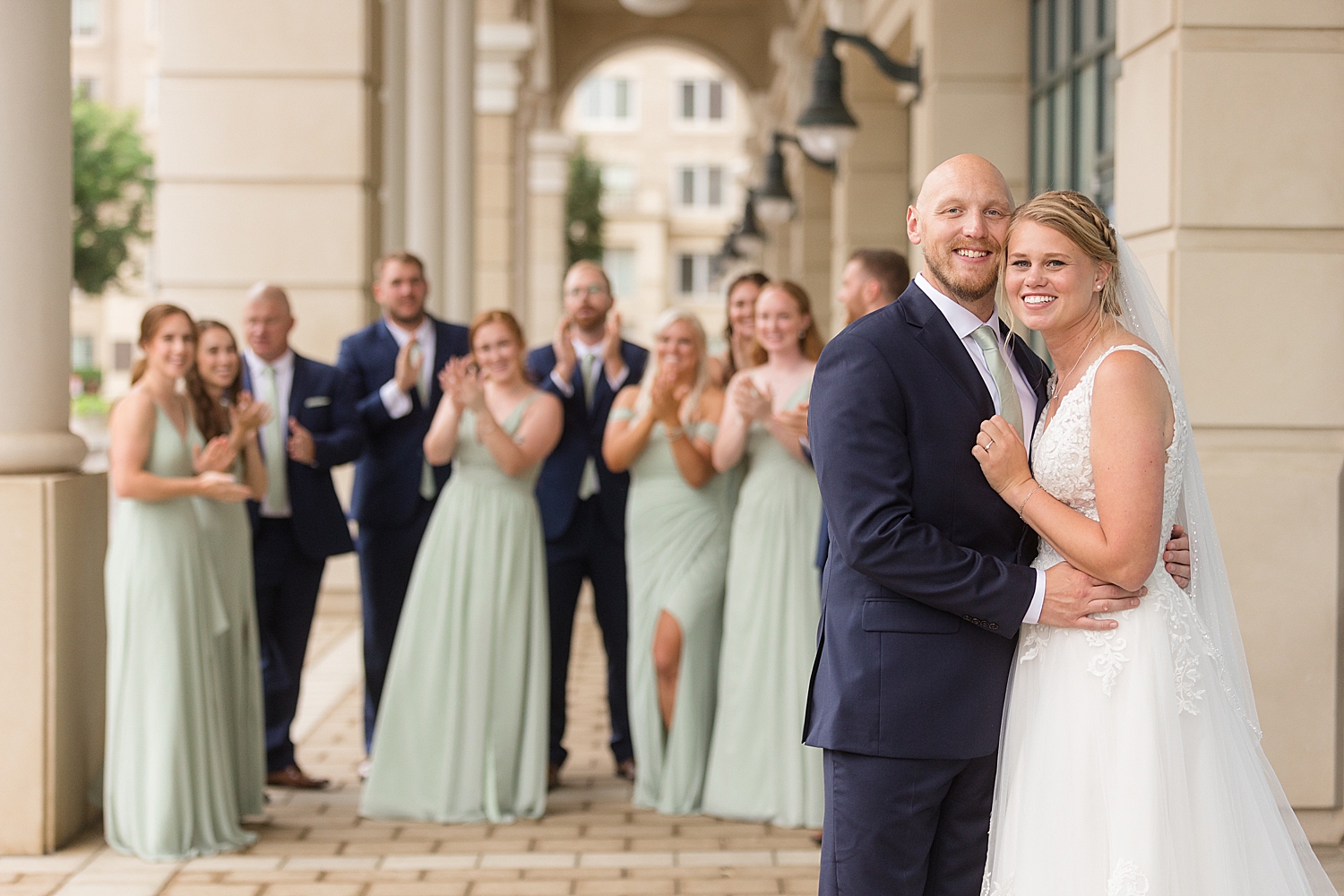 full wedding party photo, guys in navy, girls in sage