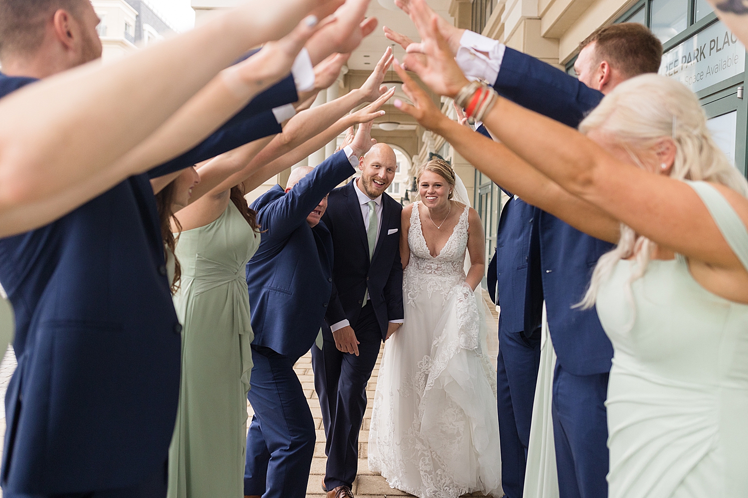 full wedding party photo, guys in navy, girls in sage tunnel