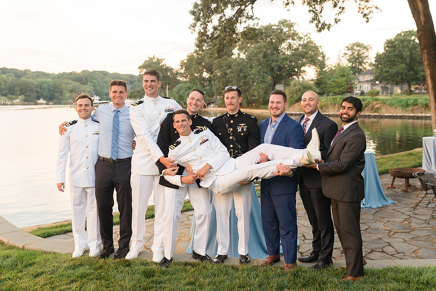 guests taking a picture holding up groomm