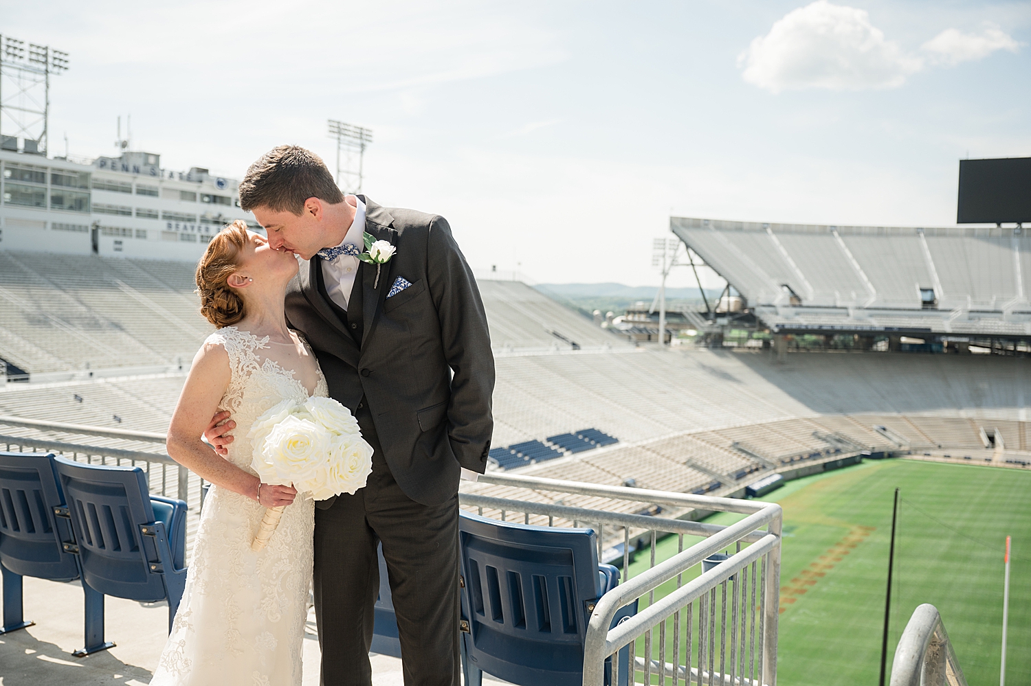 bride and groom kiss in stands at beaver stadium