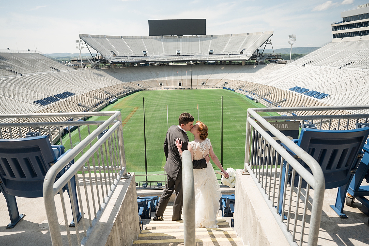 bride and groom kiss in stands at beaver stadium