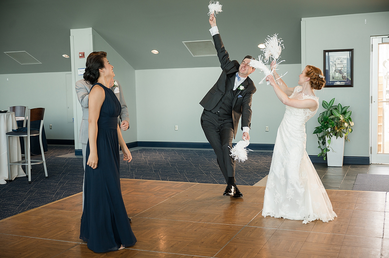 bride and groom cheering with pom poms