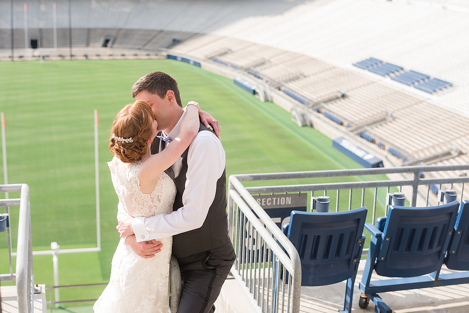 bride and groom kiss in stands at beaver stadium