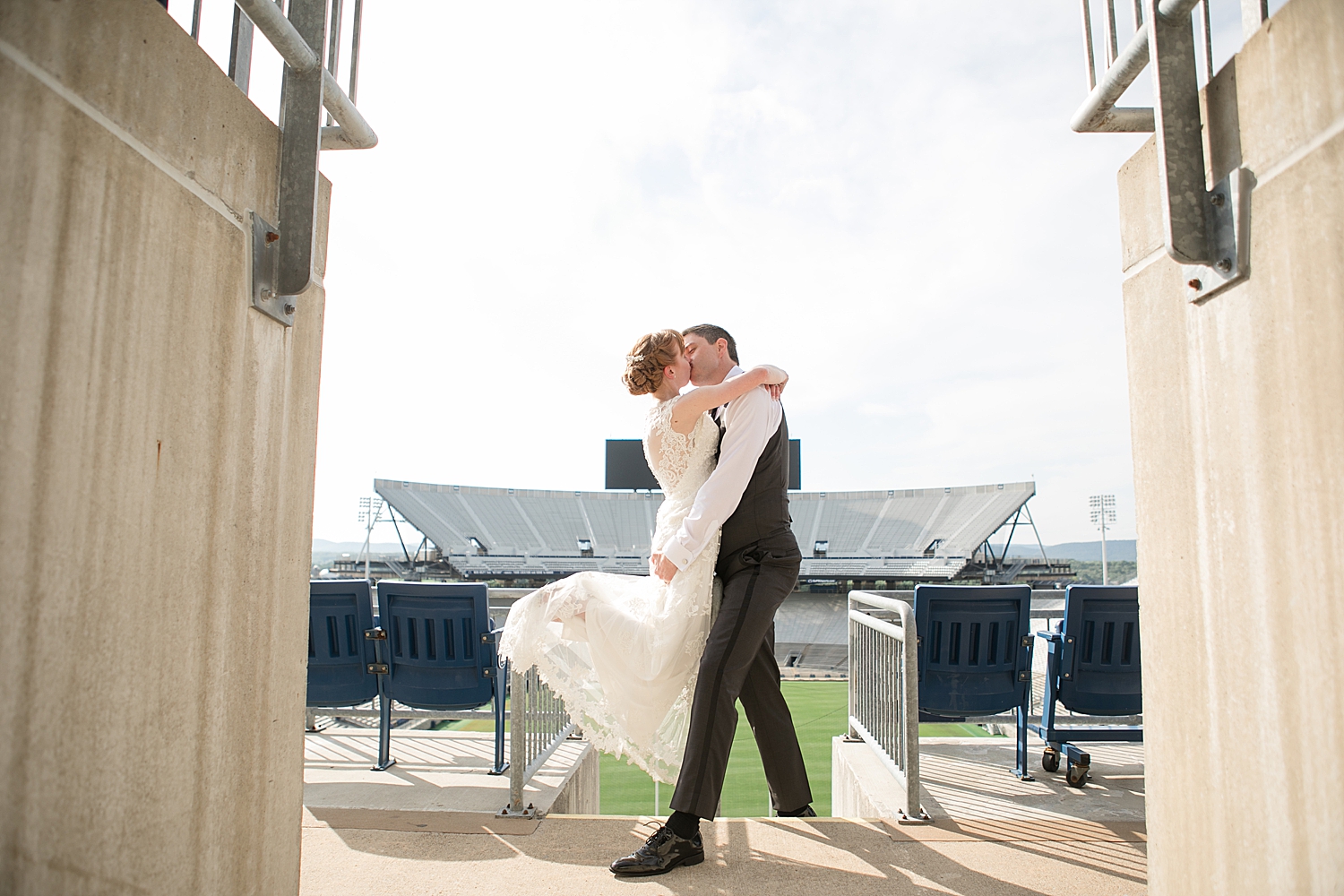 bride and groom kiss in stands at beaver stadium