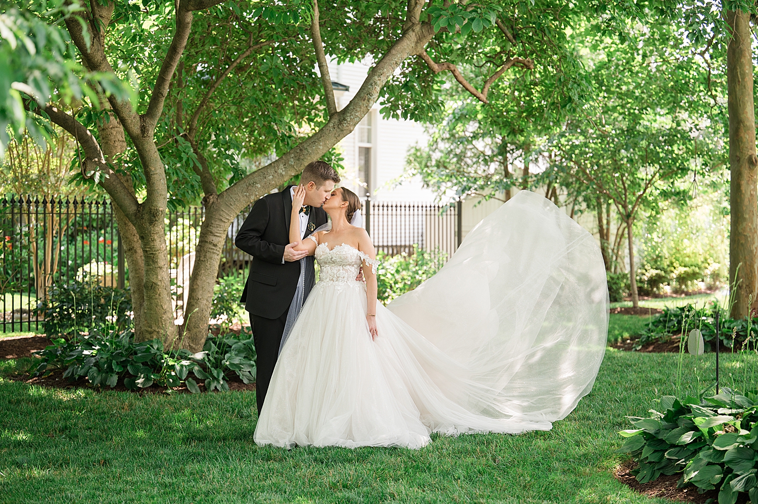 bride and groom kiss while skirt floats in the air