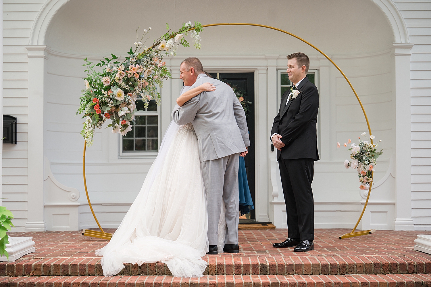 dad hugs bride at the end of the aisle