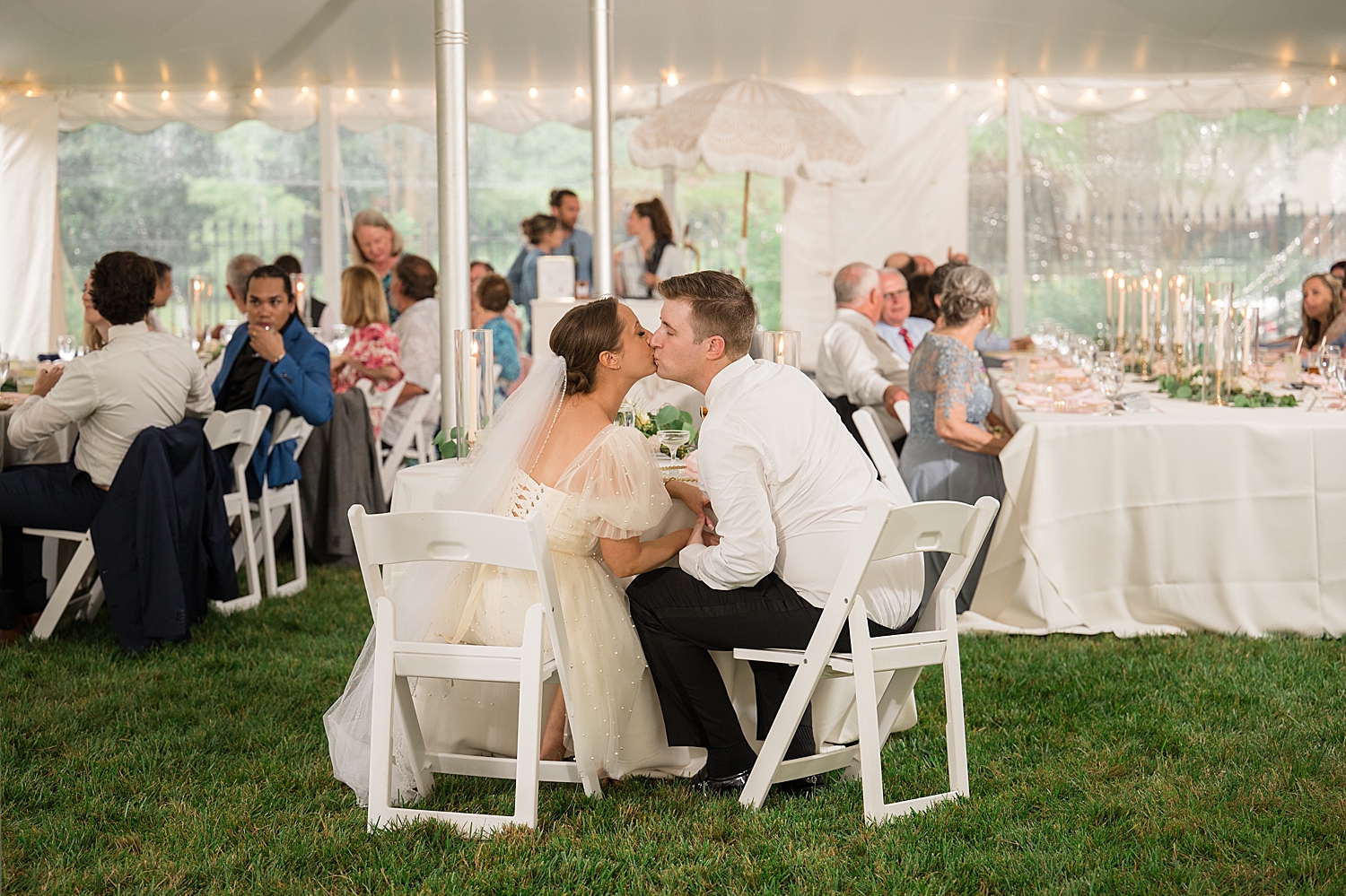 bride and groom kiss at sweetheart table