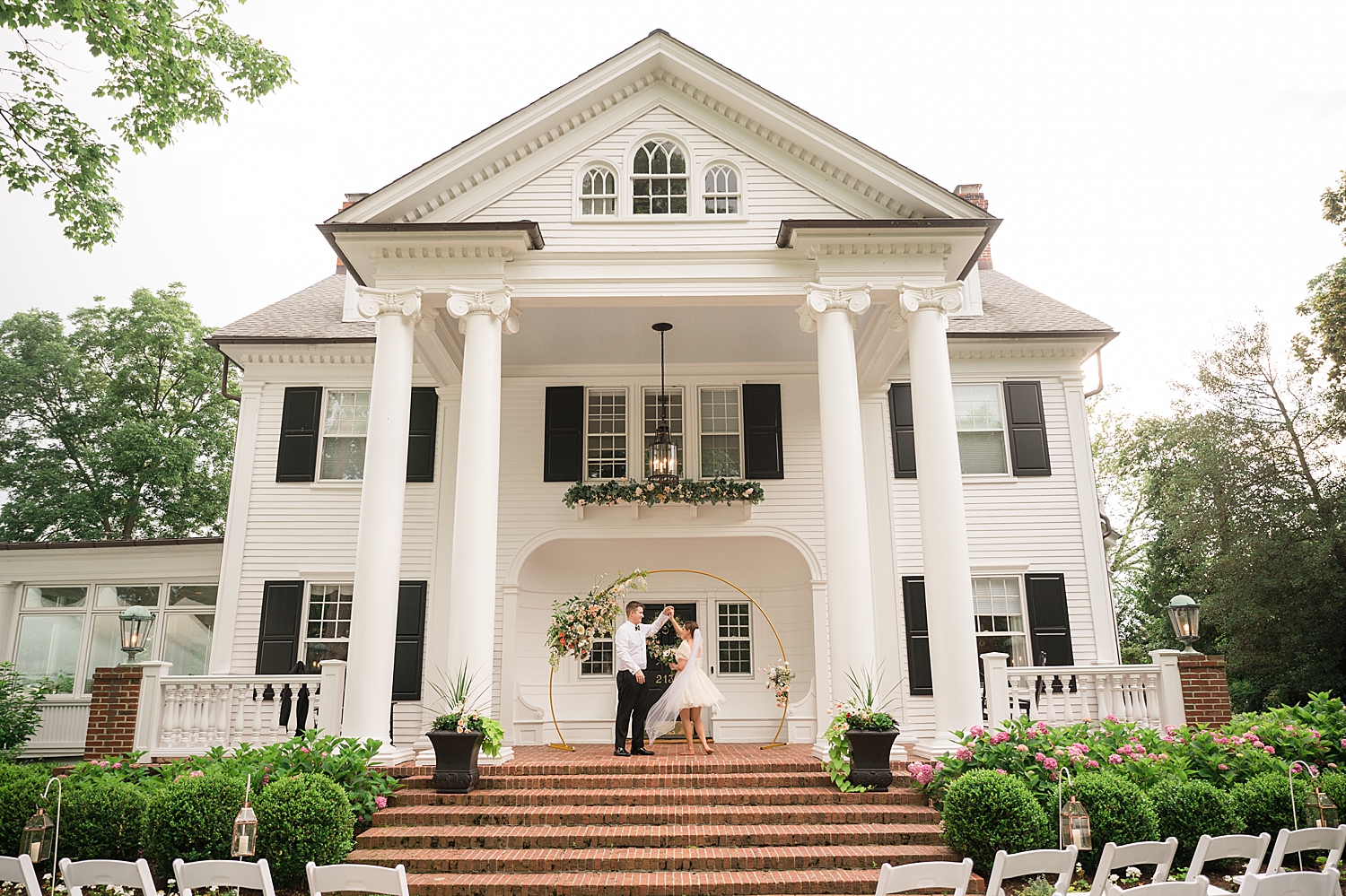 groom spins bride in front of the building