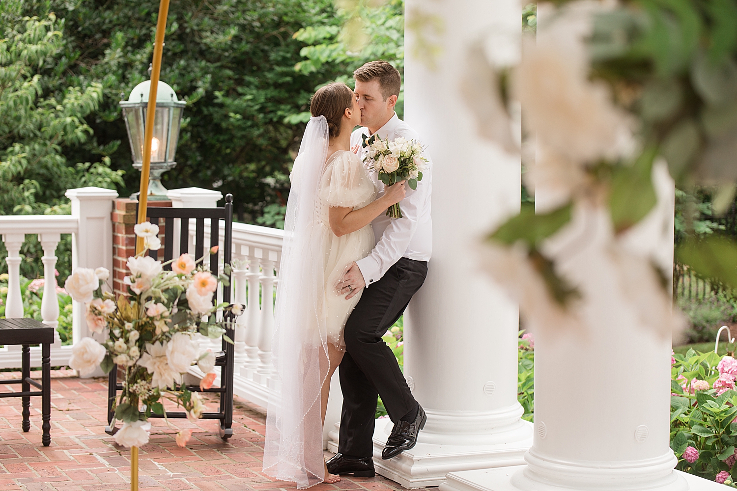 bride and groom kiss against a pillar