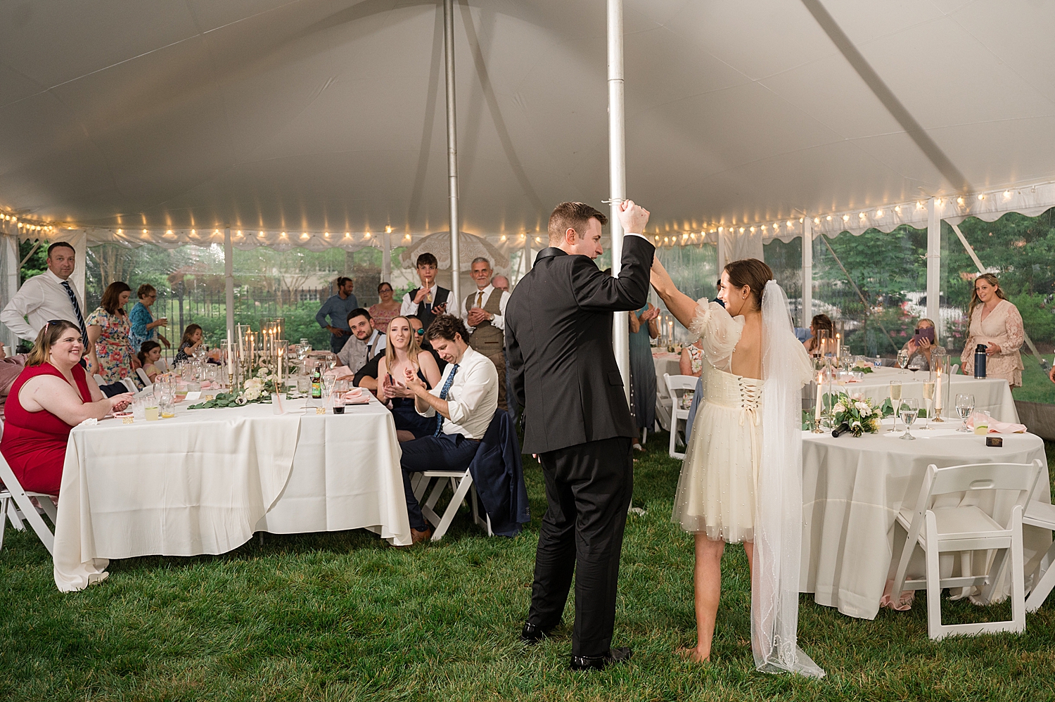 bride and groom hold hands in the air