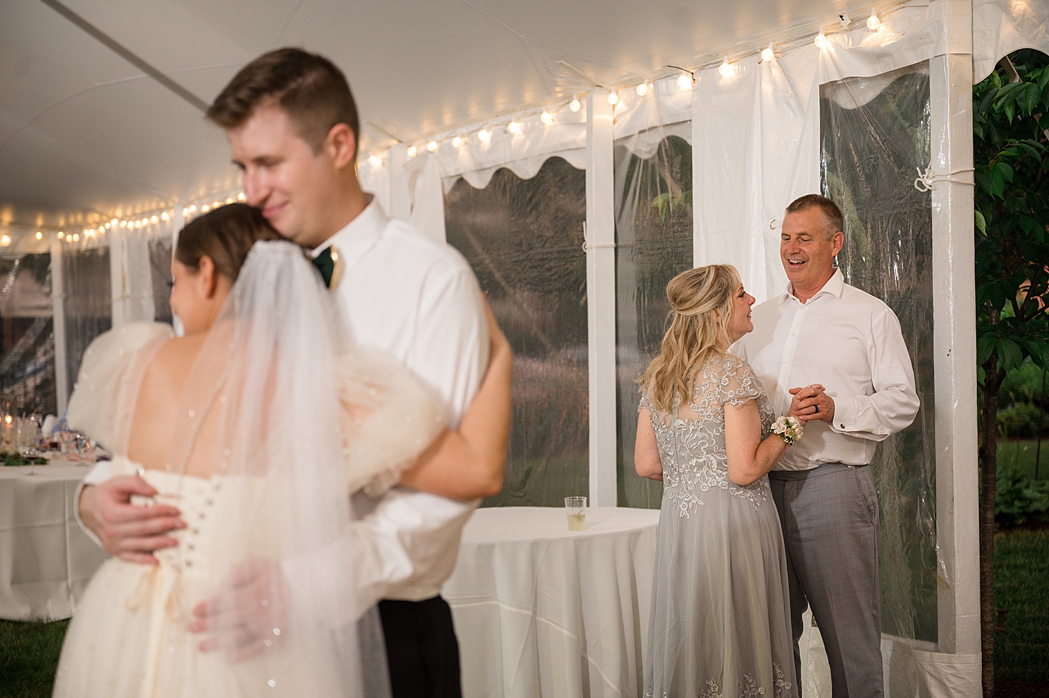 candid guests dancing at tented reception