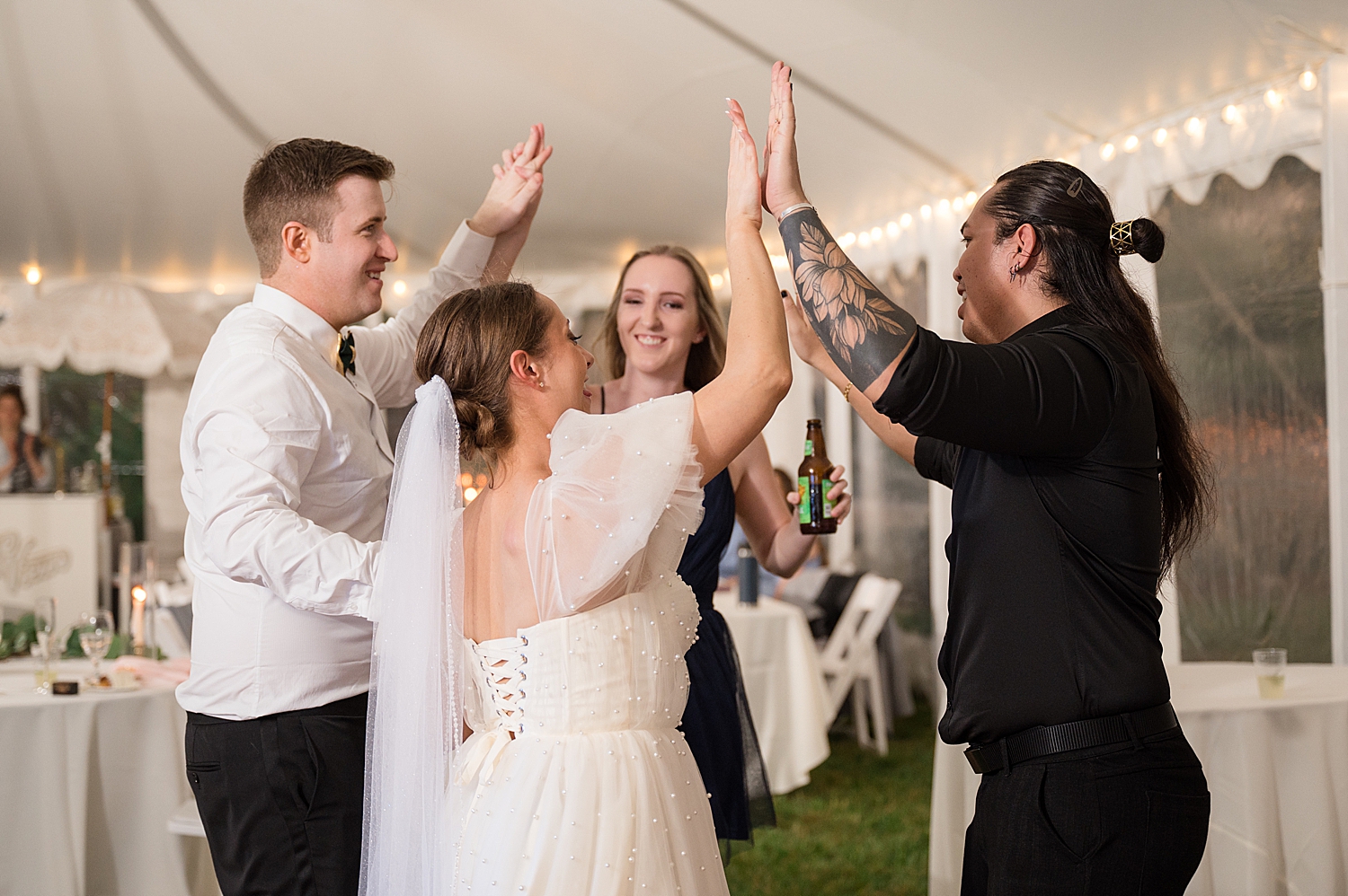 candid guests dancing at tented reception