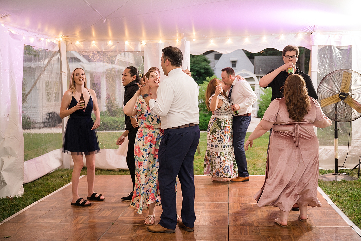 candid guests dancing at tented reception