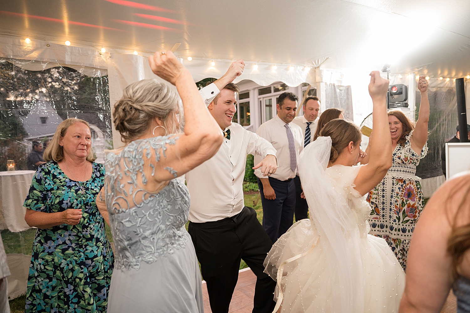 candid guests dancing at tented reception