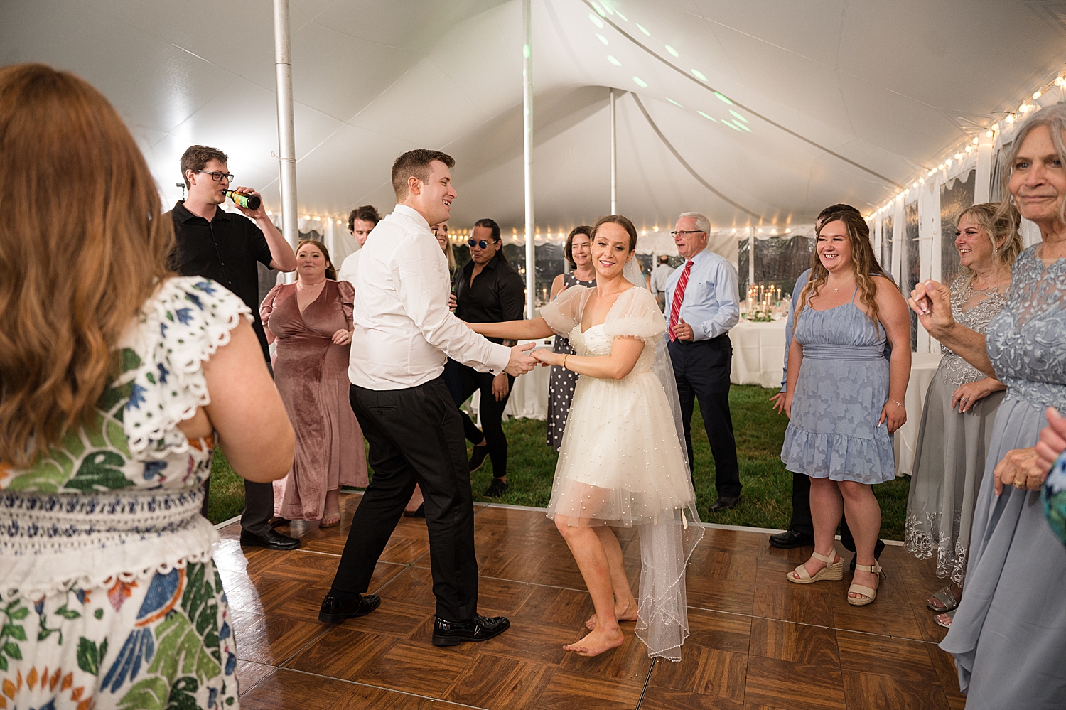 candid guests dancing at tented reception