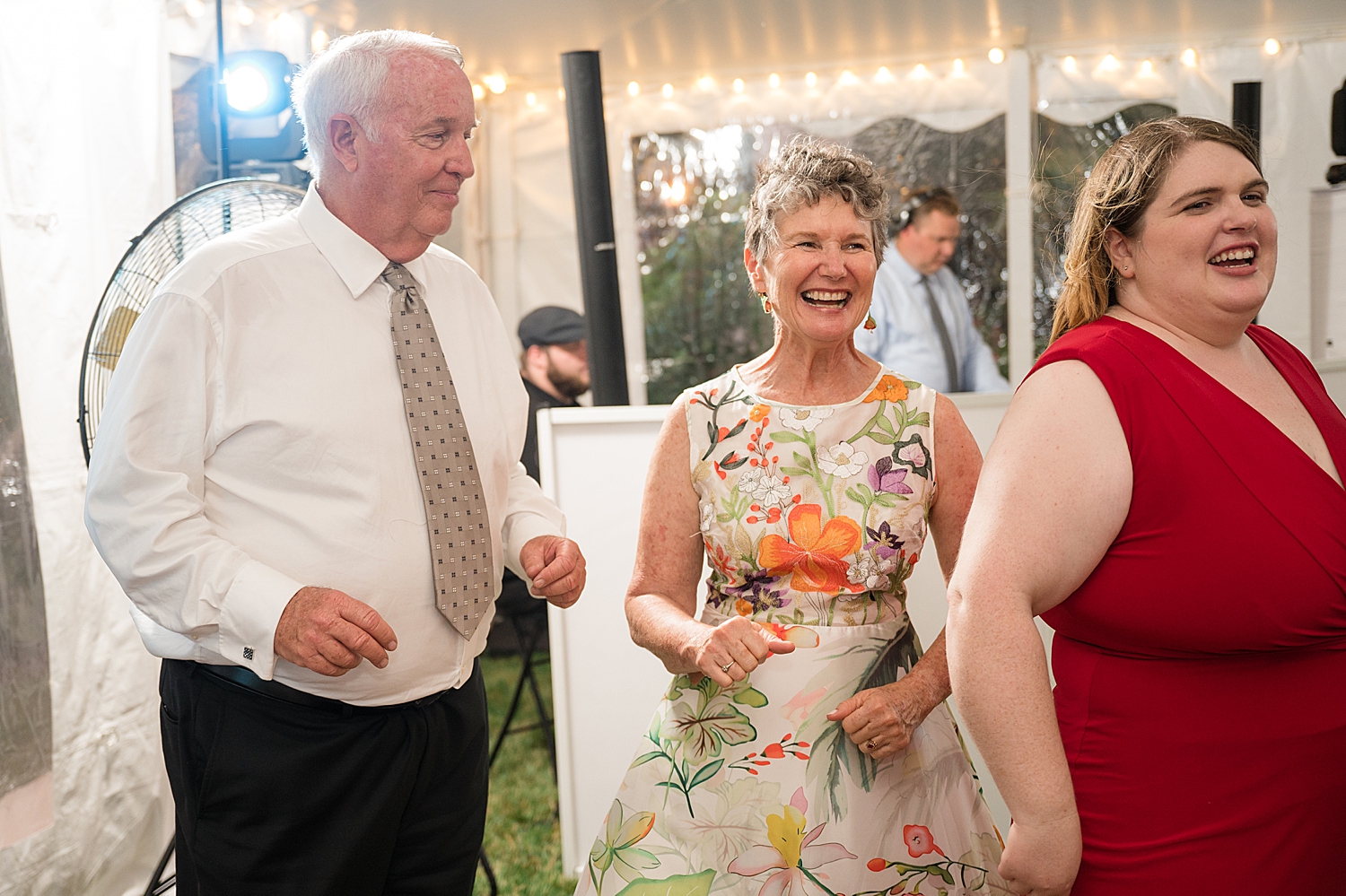 candid guests dancing at tented reception