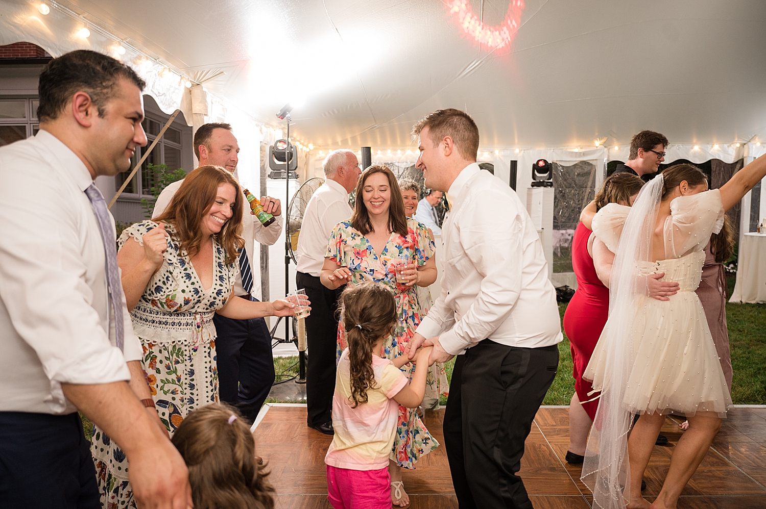 candid guests dancing at tented reception