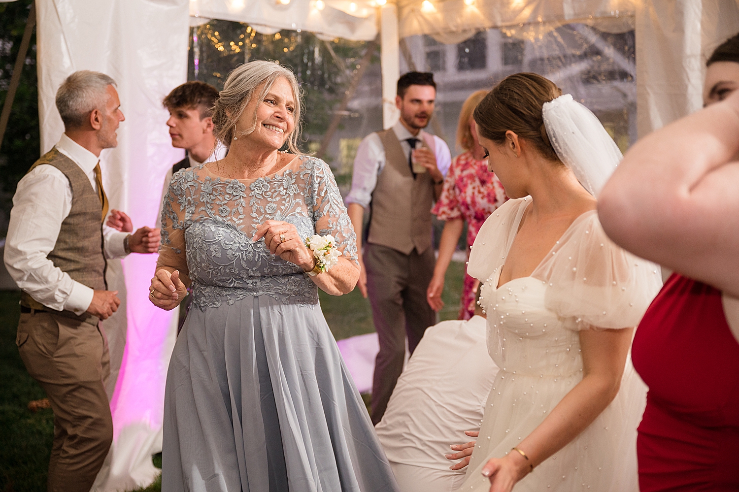 candid guests dancing at tented reception