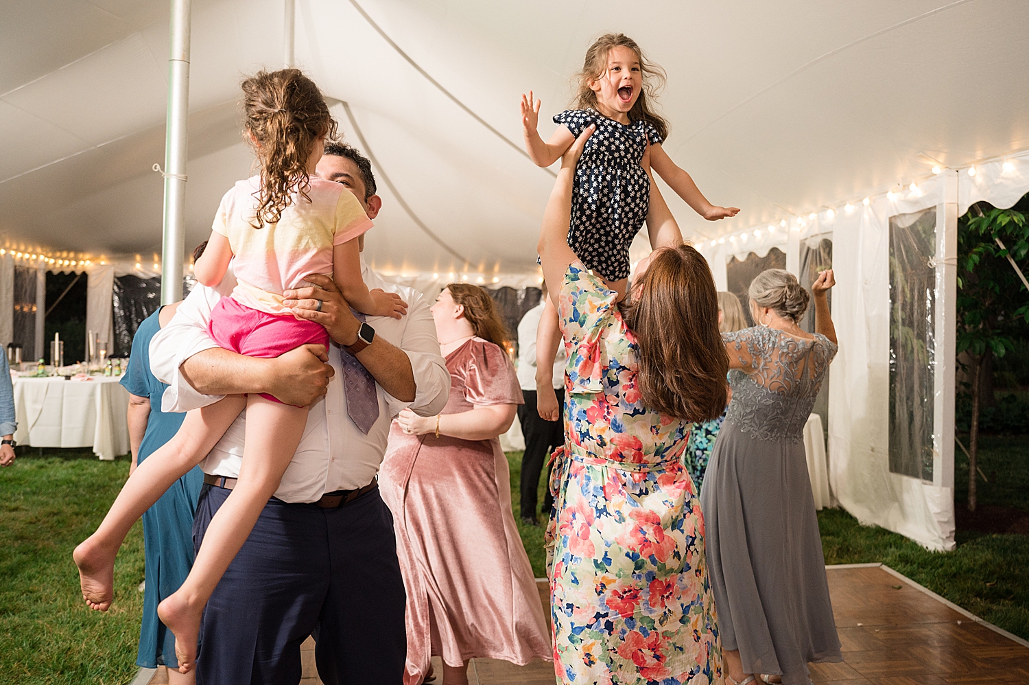 candid guests dancing at tented reception