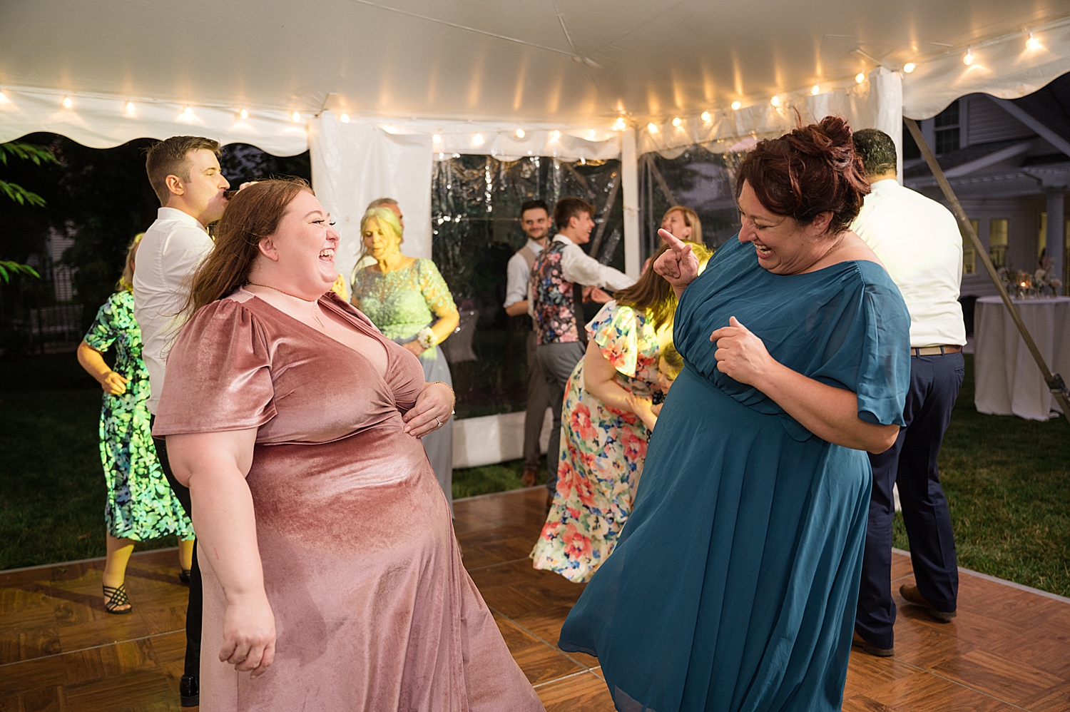 candid guests dancing at tented reception