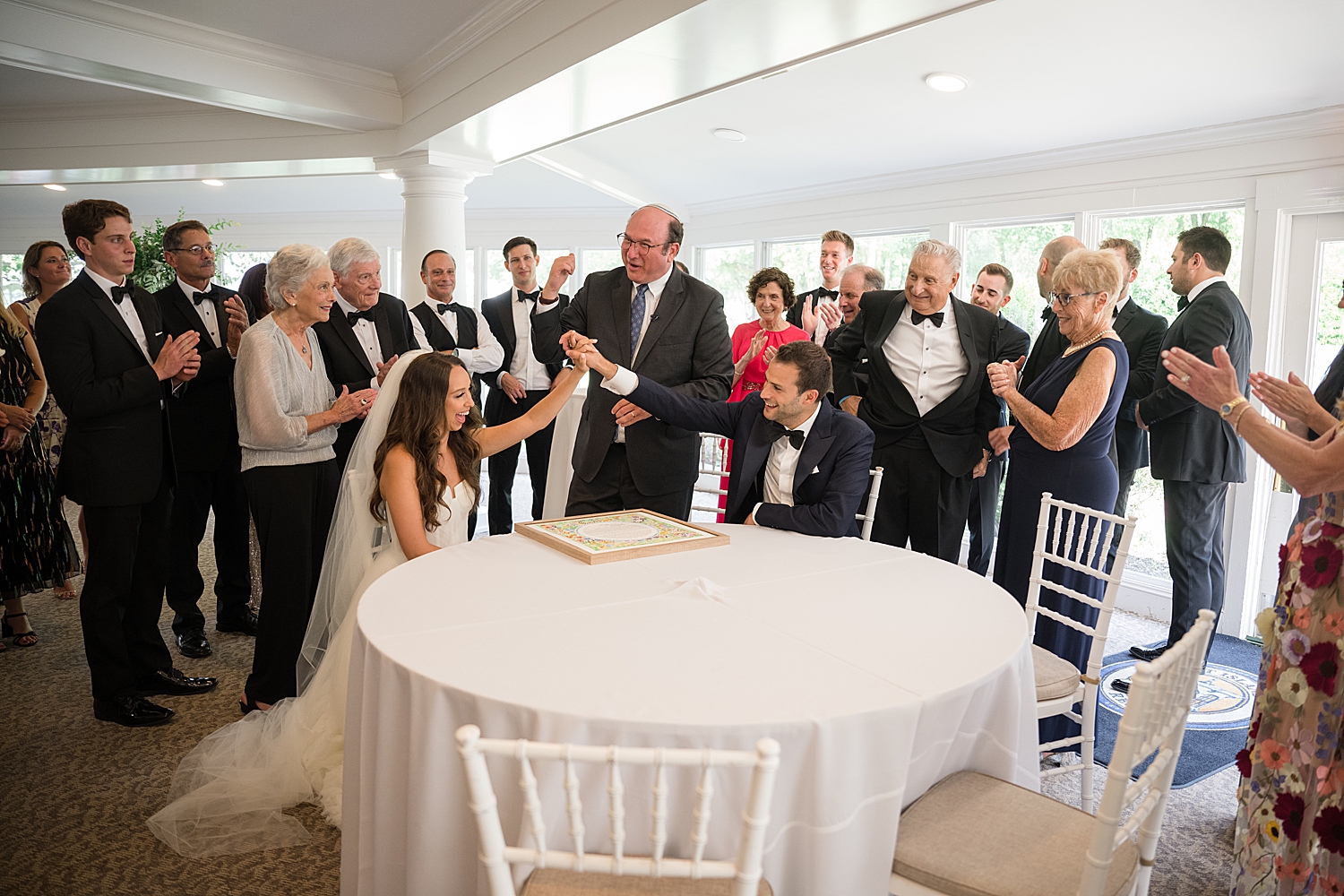 bride and groom sign the ketubah ahead of jewish ceremony