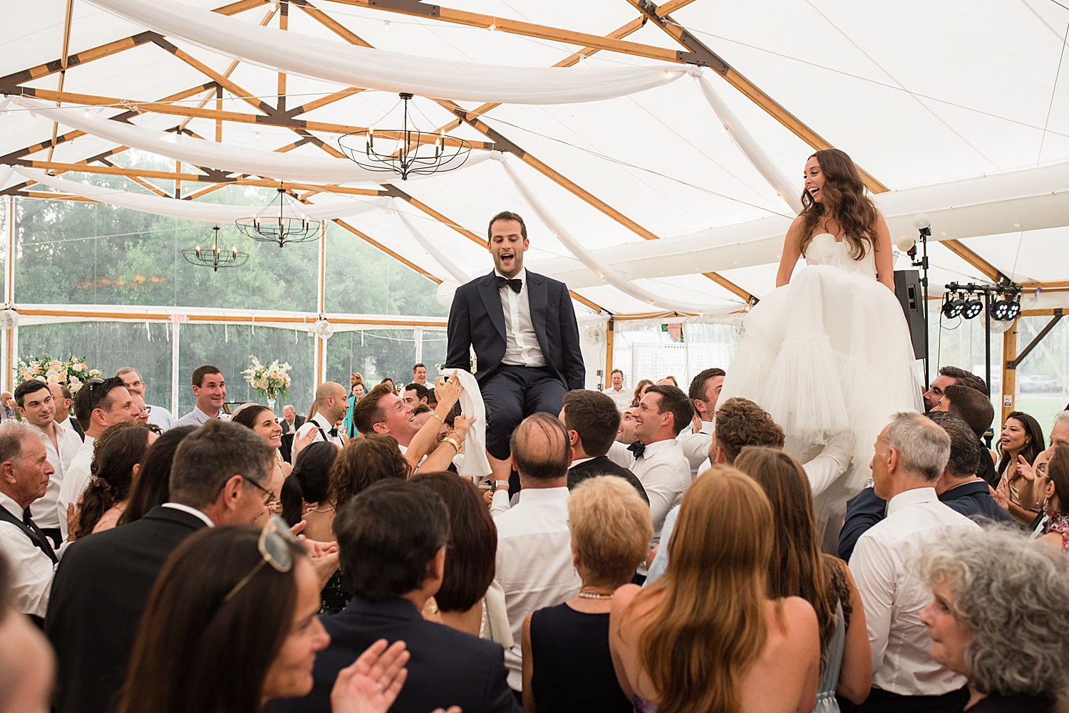 bride and groom on chairs during horah