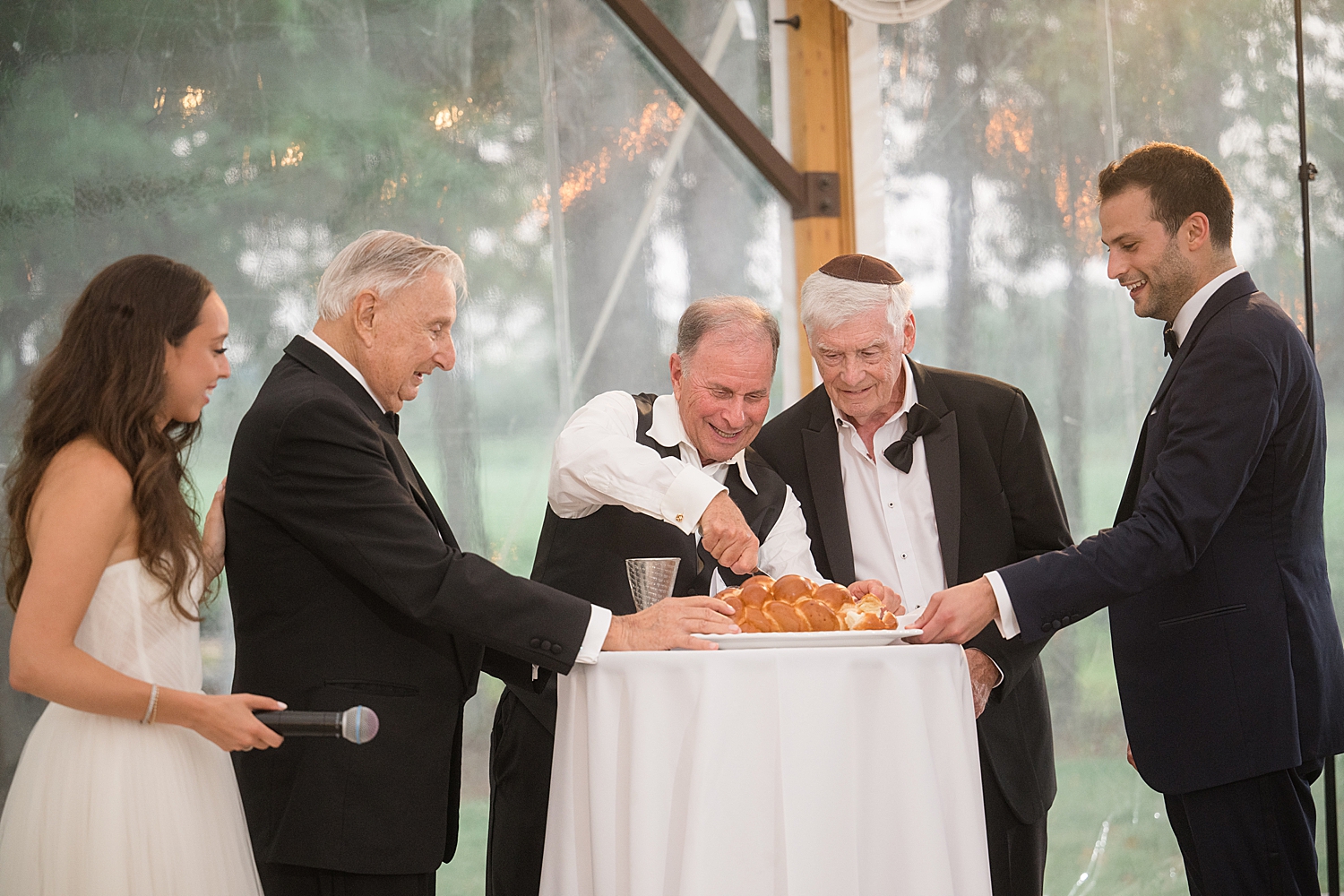 families cutting challah bread at wedding