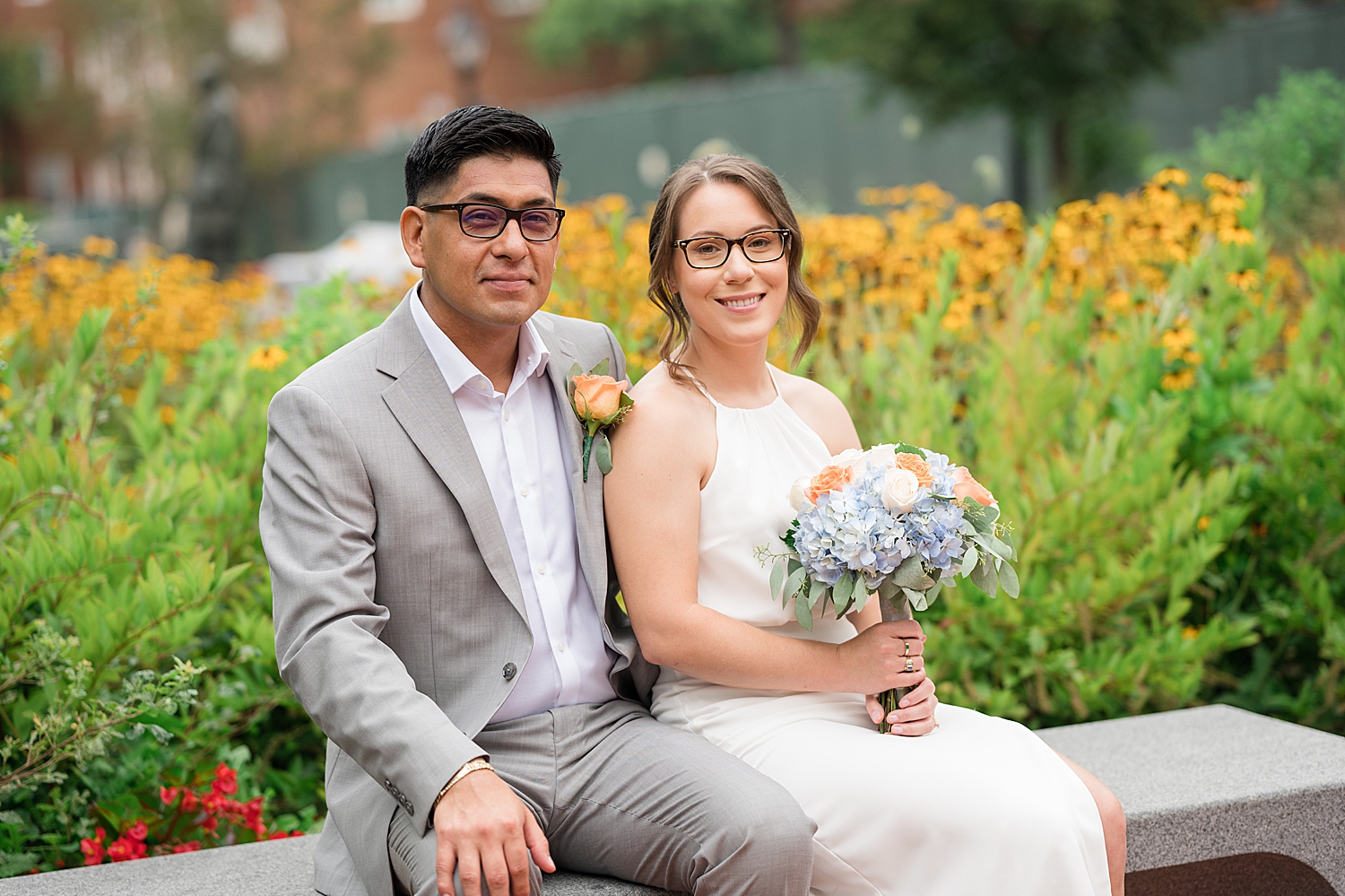 bride and groom sit on bench together