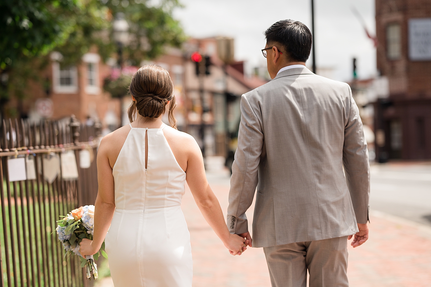 bride and groom walk hand in hand