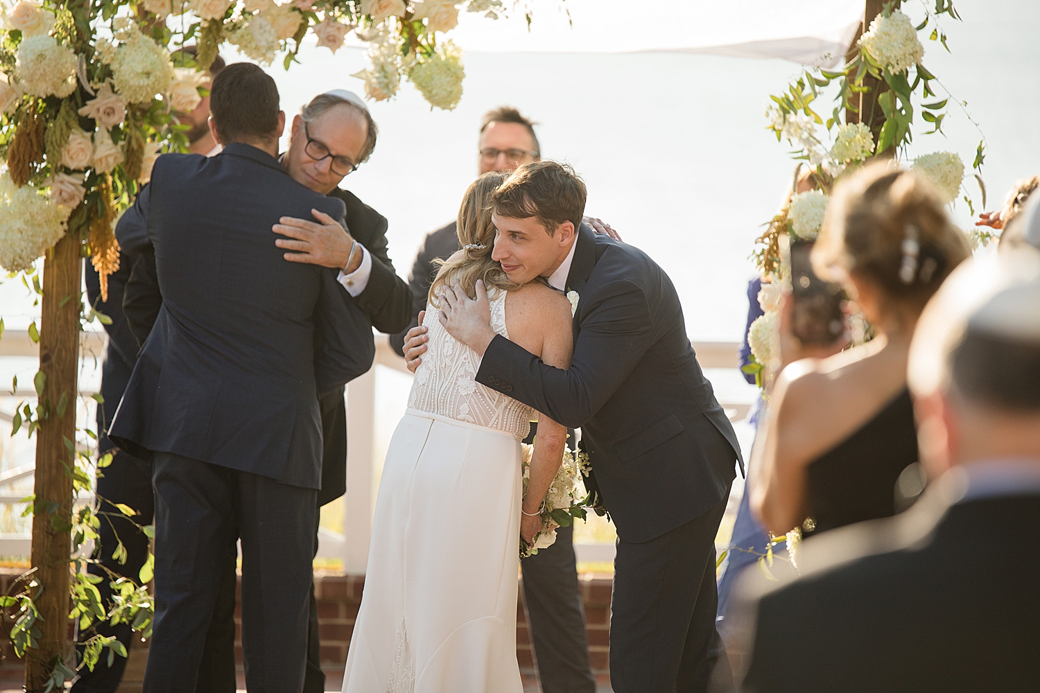 bride and groom hug family